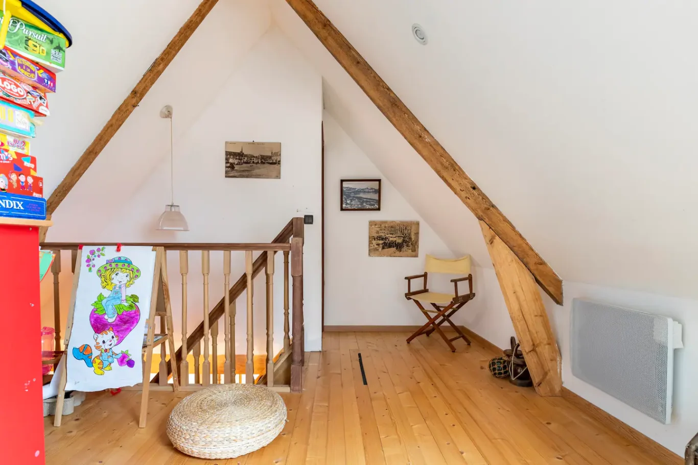 Accès à l'étage, dégagement sur mezzanine A salle sous les combles avec des poutres apparentes et un coin cosy avec une chaise.