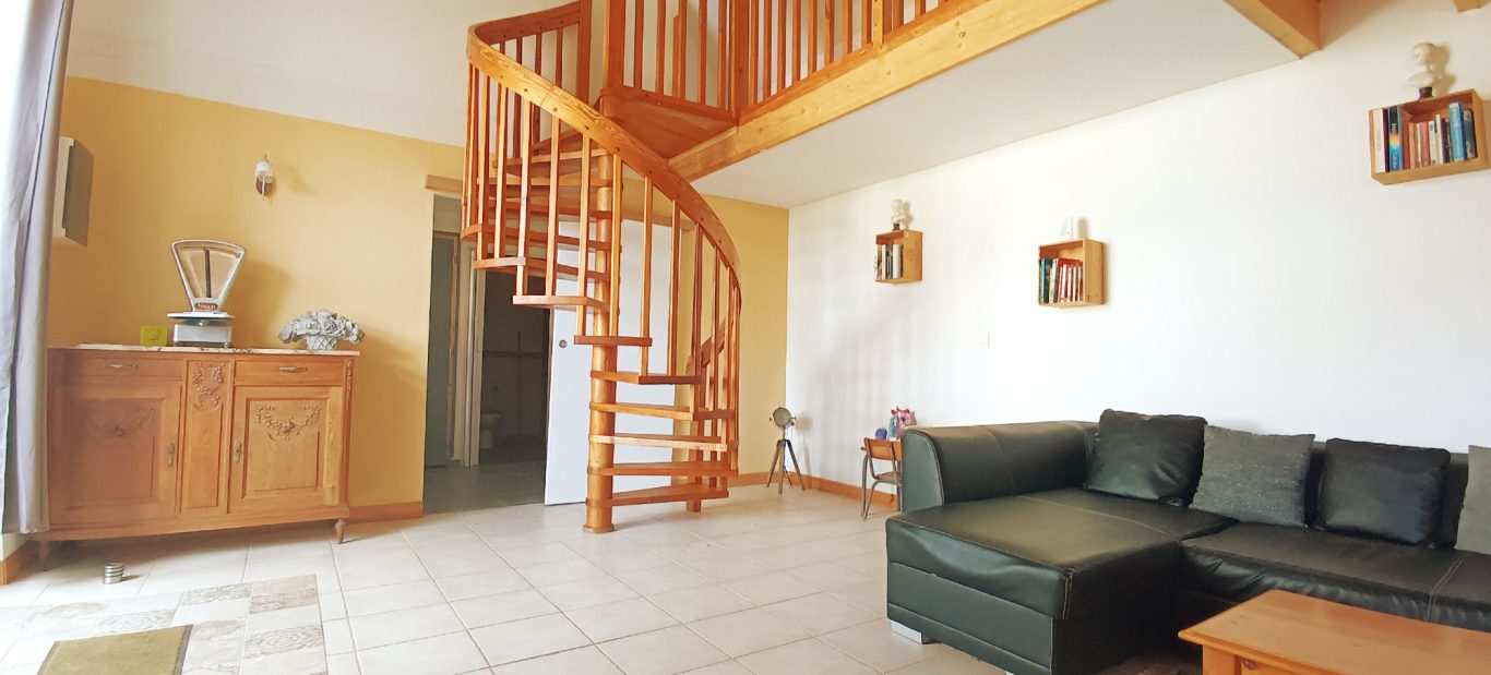 Pièce de vie lumineuse avec tv et livres à disposition